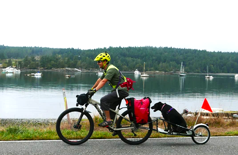 Luis biking with dog.
