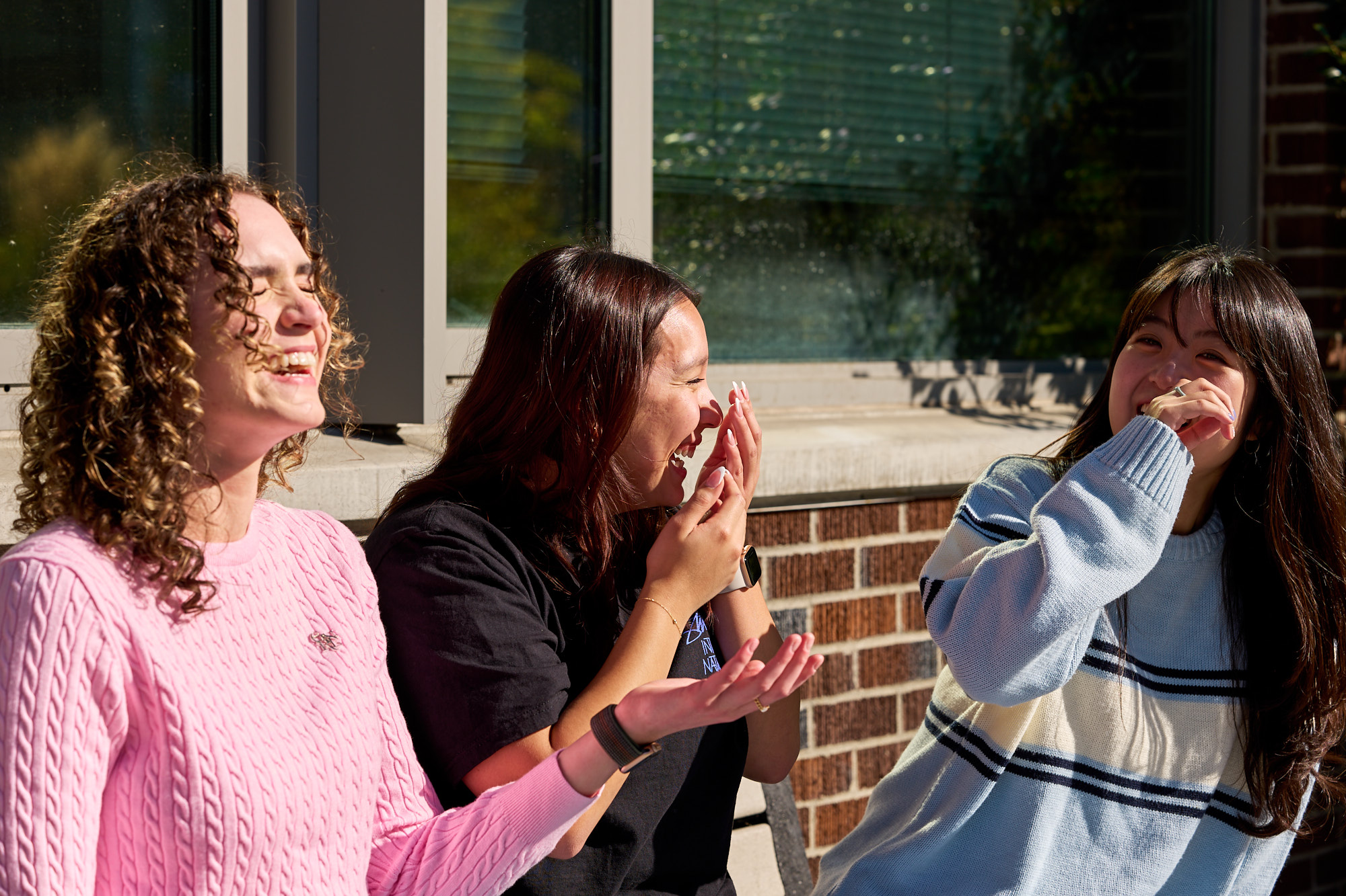 Three students laughing.