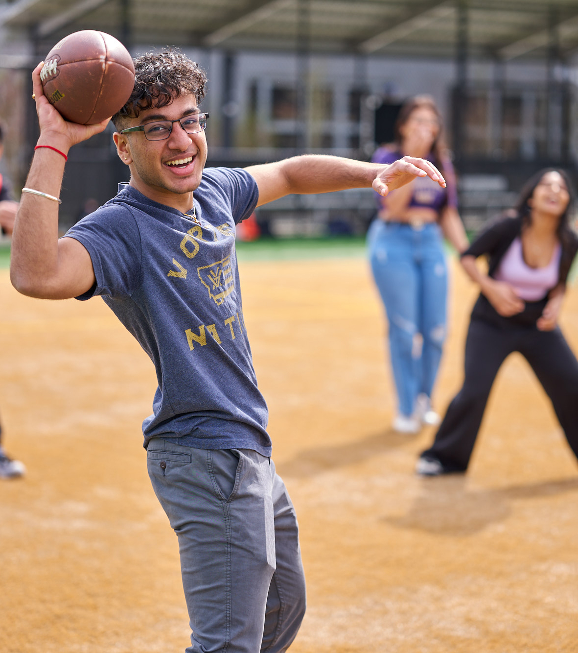 Image of a student playing football with other students